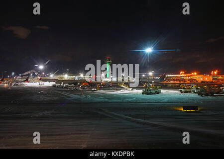 Night view of the operations mess and delays at the John F. Kennedy International Airport (JFK) after the bomb cyclone winter snow storm Grayson. Stock Photo