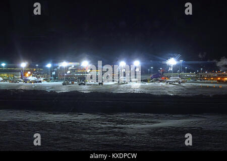 Night view of the operations mess and delays at the John F. Kennedy International Airport (JFK) after the bomb cyclone winter snow storm Grayson. Stock Photo