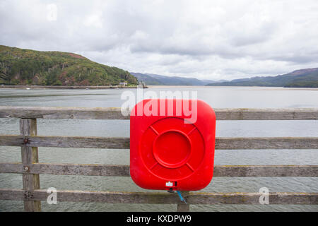 Lifebuoy on railway bridge with view towards Mawddach estuary in Barmouth Gwynedd Wales UK Stock Photo