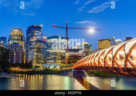 Calgary downtown at dusk with Peace Bridge over Bow river, Alberta, Canada