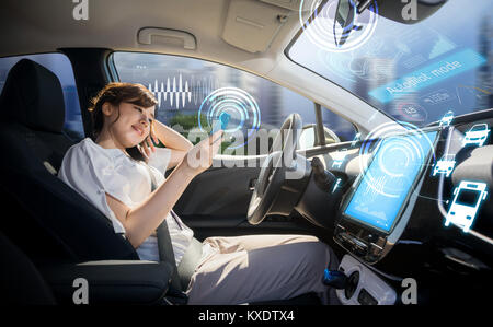 woman using smart phone in autonomous car. self driving vehicle. driverless car. autopilot. automotive technology. Stock Photo