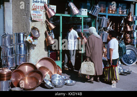 Traditional Turkish Family Shopping Outside a Copper Ware Shop in the Historic Market District and Old Town of Ulus, Ankara, Turkey Stock Photo