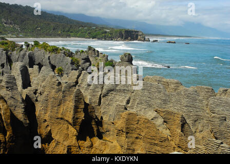 Punakaiki,Paparoa National Park. Foreground of 'Pancake rock' formation with scenic sea and Razorback Point in background. Stunning and picturesque. Stock Photo