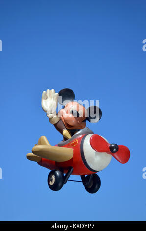 Monchique, Faro - Portugal, 30th, March 2013. Studio image of Mickey Mouse figure in a aeroplane with a blue sky background. Stock Photo