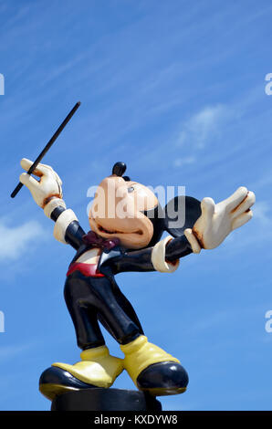 Monchique, Faro - Portugal, 30th, March 2013. Studio image of Mickey Mouse maestro figure Standing on a wall with a blue sky backgroun Stock Photo
