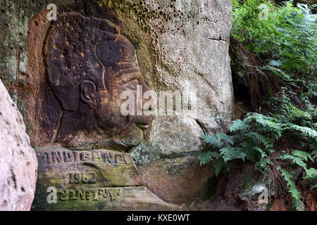 BEAUFORT, LUXEMBOURG - CIRCA AUGUST 2016 Bas-relief on the rock and green leaves Stock Photo