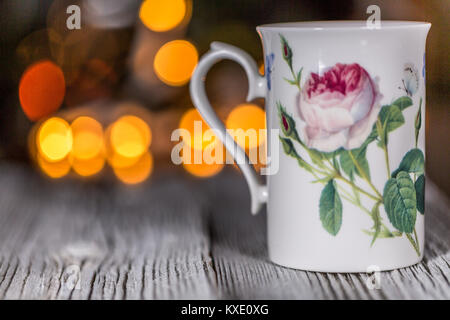 Empty Cup On Saucer on a wooden table with electric garland in bokeh with lights in defocused background Stock Photo