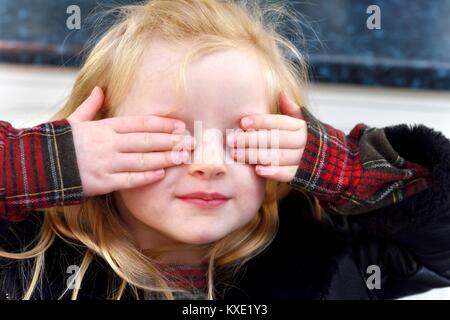5 Year old girl playing hide and seek Stock Photo