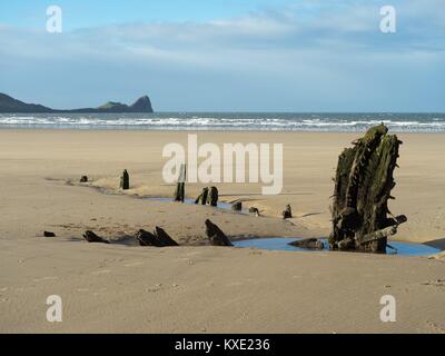 Remains of the wreck of the Helvetia at Rhossili Bay, Gower with Worm's Head in the background Stock Photo