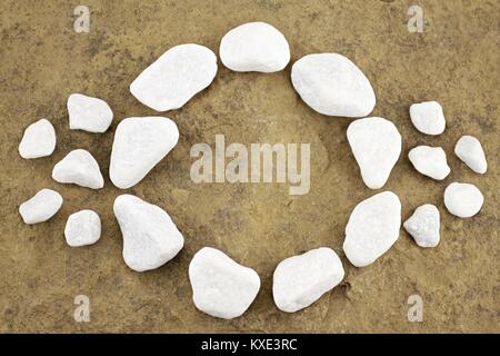 Pattern with circle of pebbles on brown stone Stock Photo