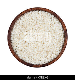 Risotto rice in wooden bowl isolated on white background. Top view Stock Photo