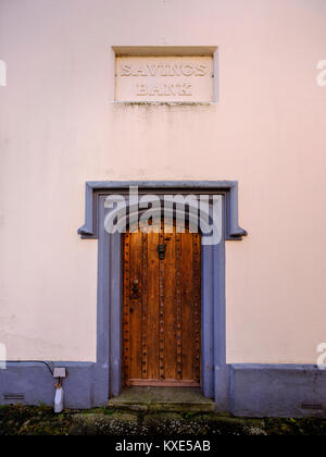 Formerly a bank this now pink house displays the sign ‘Savings Bank’ sign above a large ornate wooden door. Stock Photo