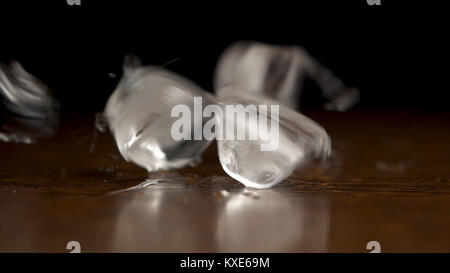 Flying or falling ice cubes on black or dark space. Ice cibes. Close-up view of shiny melting ice cube with water drops on black Stock Photo