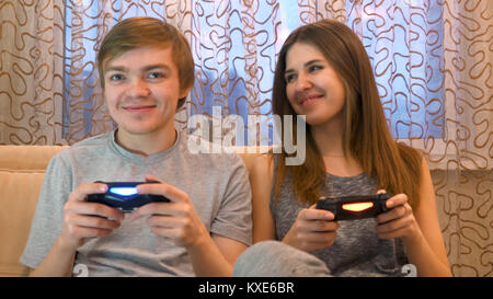 Couple playing video games. Young couple playing video games in their apartment. Young couple playing video games in the living room. Competitive couple playing video games Stock Photo