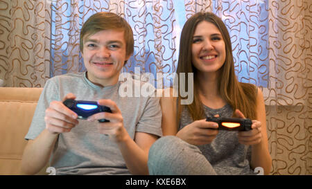 Couple playing video games. Young couple playing video games in their apartment. Young couple playing video games in the living room. Competitive couple playing video games Stock Photo