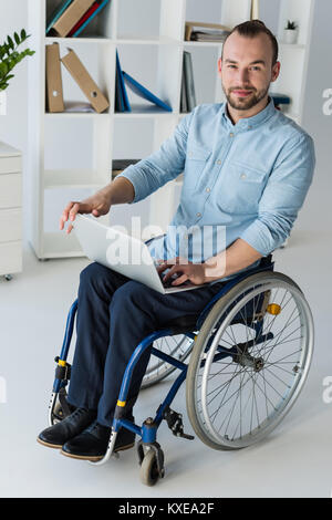 businessman in wheelchair using laptop Stock Photo