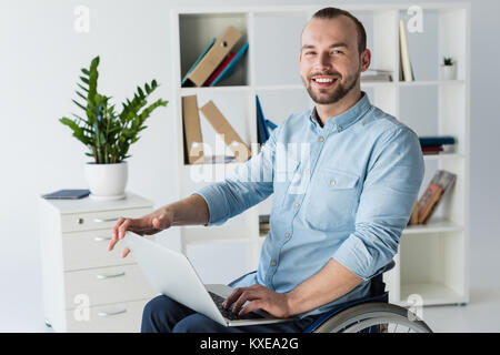 businessman in wheelchair using laptop Stock Photo