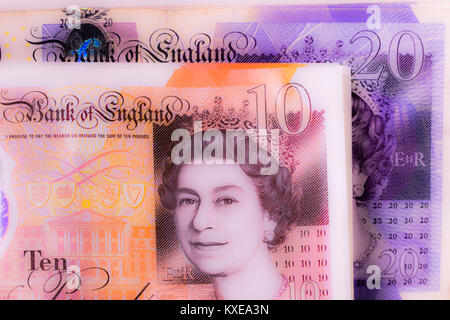 New £10 notes (ten pounds) with £20 notes behind. Sterling pound currency closeup. Concept of UK / British money, income, expenditure, capital, etc. Stock Photo