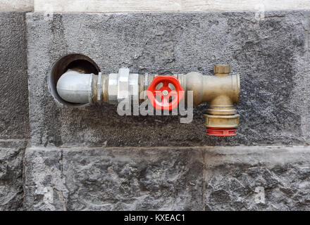 Hydrant with water hoses and fire extinguish equipment on wall Stock Photo