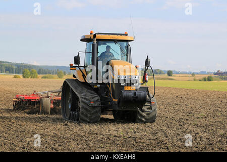 SALO, FINLAND -SEPTEMBER 6, 2014: Challenger MT765C crawler tractor and cultivator on field. MT765C has Caterpillar 8.8L 6-cyl diesel engine. Stock Photo