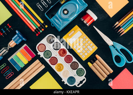 Flat lay composition of colorful school supplies isolated on dark board background Stock Photo