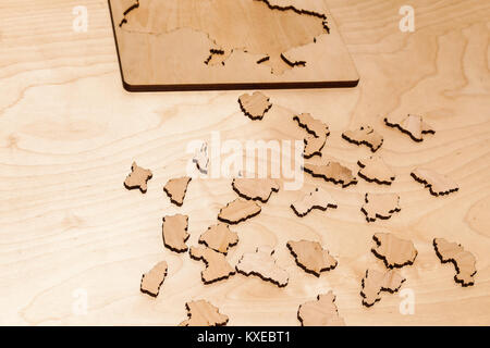 Wooden puzzles lie on a wooden table Stock Photo