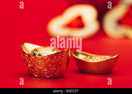 close-up shot of chinese golden ingots on red surface Stock Photo