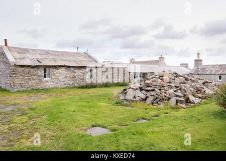 thick roofing flagstones or slates next to traditional stone building with slate roof on Westray, Orkney Islands, Scotland, UK Stock Photo
