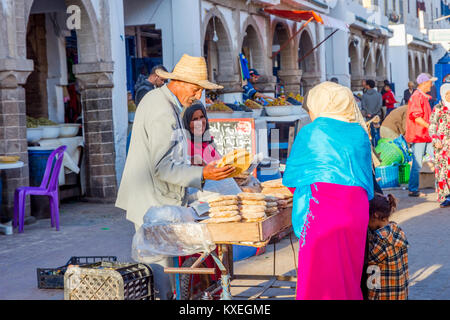ESSAOUIRA, MOROCCO - DECEMBER 13: Senior couple selling traditional moroccan bread on the street in Essaouira. December 2016 Stock Photo