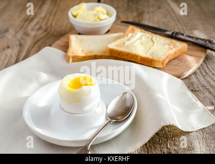 Boiled egg with crispy toasts on the wooden table Stock Photo