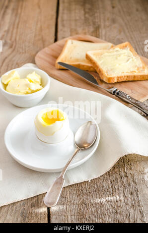 Boiled egg with crispy toasts on the wooden table Stock Photo