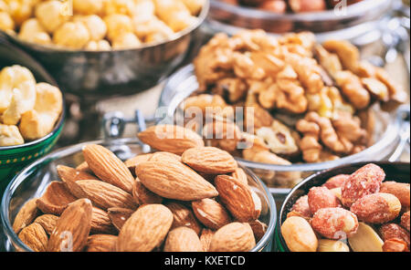 Almonds, peanuts and other nuts in bowls Stock Photo