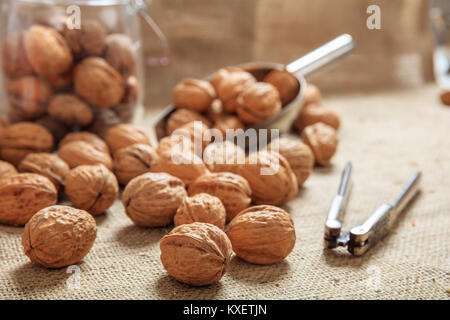 Walnuts, a scoop and an old nutcracker on a table Stock Photo