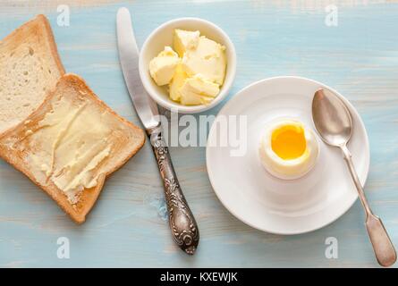 Boiled egg with crispy toasts on the wooden table Stock Photo