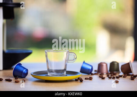 Empty coffee cup, espresso capsules and coffee beans on wooden table, blur background, Closeup view with details Stock Photo