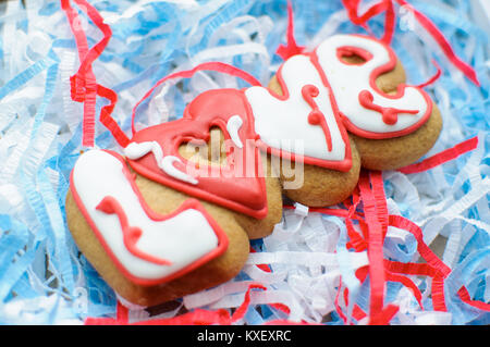 Letter cookies for Valentine's day or for a wedding day on the blue and white paper filler background. Top view, selective focus, copy space. Stock Photo