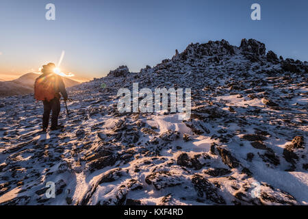 figure on snowy mountain in Wales with sunset Stock Photo