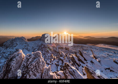 figure on snowy mountain in Wales with sunset Stock Photo