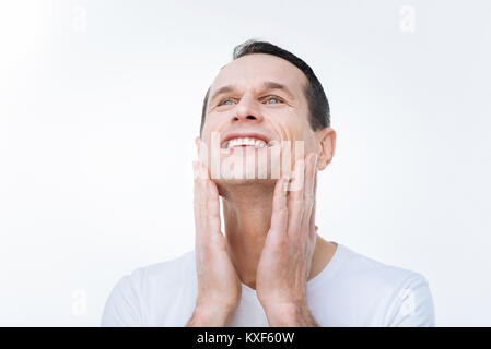 Happy positive man touching his cheeks Stock Photo