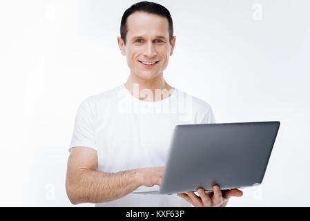 Delighted happy man using a laptop Stock Photo