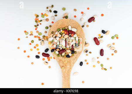 Mixed legumes in a wooden spoon on white background Stock Photo