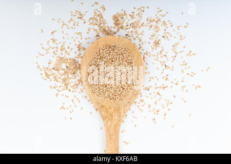 Sesame seeds in a wooden spoon on white background Stock Photo