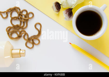 Top view of women's business work desk. Fresh flat lay fashion feminine workspace with  cup of coffee, cosmetics and jewelry on white background Stock Photo