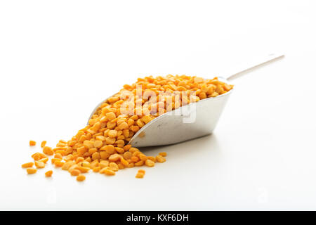 Raw split peas in a metallic scoop on white background Stock Photo