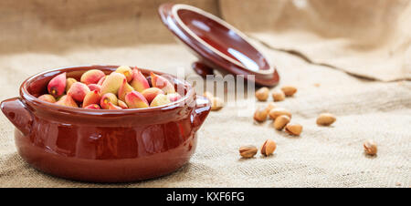 Fresh pistachios in shell in a ceramic pot Stock Photo