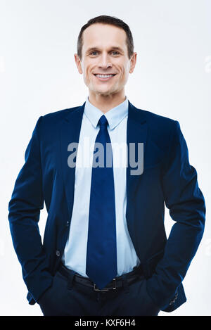 Joyful successful businessman putting hands in pockets Stock Photo