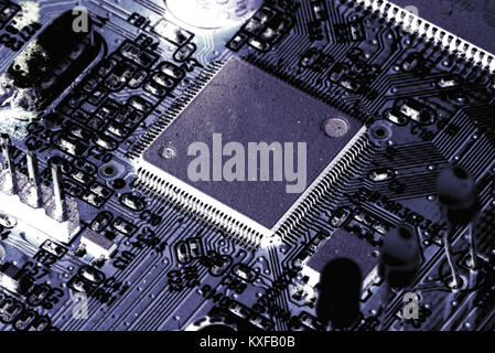 Electronic PCB printed circuit board in macro close-up with transistors circuitry and electric hardware elements including computer chip with copy spa Stock Photo