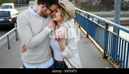 Couple kissing in city during sunset Stock Photo
