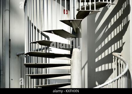 Elegant metal exterior spiral staircase on the side of a house in Singapore Stock Photo