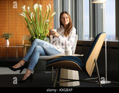 Cologne, Germany. 10th Jan, 2018. A model sitting on the 'Nihan' armchair in Cologne, Germany, 10 January 2018. The IMM International Furniture Fair takes place in Cologne between 15 and 21 January 2018. Credit: Oliver Berg/dpa/Alamy Live News Stock Photo